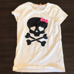 A shirt with a skeleton with a bow on it